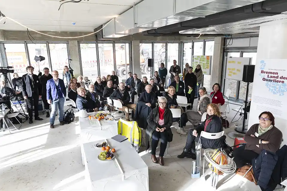 Gruppenfoto vom Think Tank-Treffen. Leute stehen in einem Raum uns schauen zur Kamera herauf.
